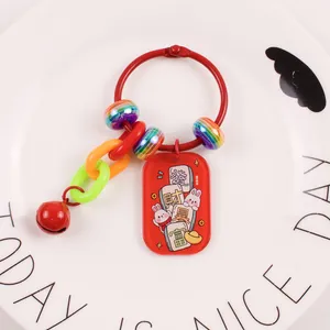 Detail of red keychain with Lucky Rabbit acrylic tag, rich text, bell and rainbow beads