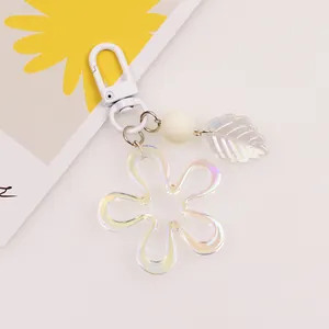 Detailed macro view of an iridescent acrylic flower keychain with leaf charm and round bead