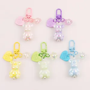 Detailed close-up of colorful pearlescent bear keychains with metal D-clips and charms
