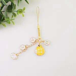 Détail d'un cordon de téléphone avec pendentif poire mignon NICI et breloques de lettres