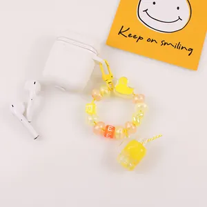 Détail d'un porte-clés à perles jaune avec breloque gobelet sur étui d'écouteurs