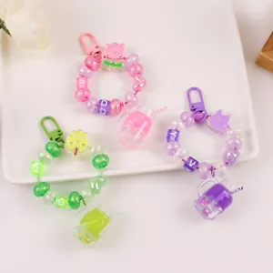 Détail de porte-clés tasse à fruits avec perles colorées et breloques de fleurs
