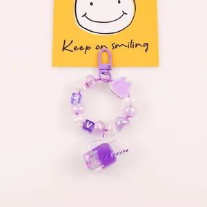 Détail du porte-clés à perles violettes avec mini gobelet et breloques de lettres