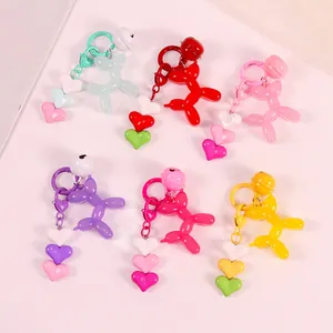Detail view of colorful resin balloon dog keychains with matching bells and heart charms