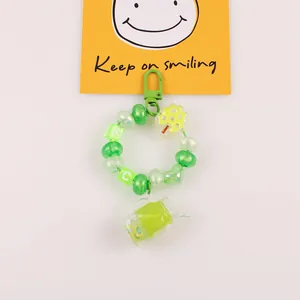 Détail du porte-clés à perles vertes avec pendentif gobelet et carte Keep on smiling
