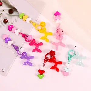 Detail of colorful balloon dog charms with heart beads and small bells on hooks