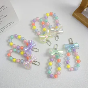 Detail of colorful macaron bead bag charms with iridescent bows and silver metal clasps