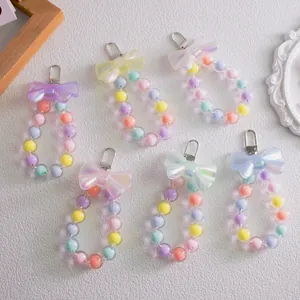 Flat lay of macaron color beaded bag charms with iridescent bows and lobster clasps