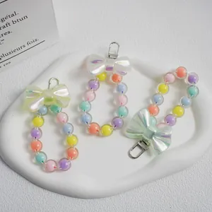 Detail of macaron beaded bag charms with iridescent bows and silver lobster clasps