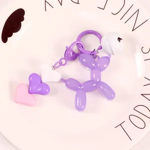 Macro view of purple jelly balloon dog keychain with heart charms and bell in ceramic tray