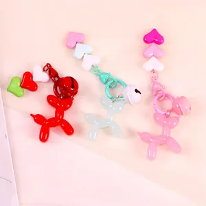 Detail of jelly-colored balloon dog keychains in red, mint green, and pink with heart beads