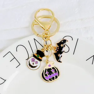 Halloween keychain with enamel ghost, black bat and pumpkin charms on golden metal ring