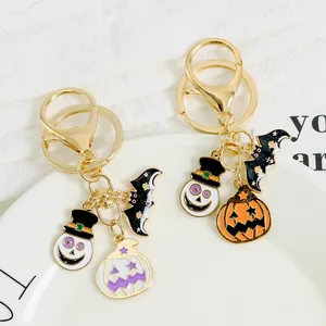 Halloween keychain with skeleton skull, pumpkin, and bat charms in gold metal finish