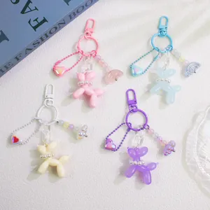 Close-up of cute resin balloon dog keychains in pink, blue, beige, and purple colors