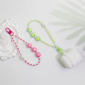 Floral beaded phone charms with pearls and colorful metal clasps in a stylish flat lay