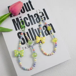 Detail of colorful beaded bag pendants with polka dot bows and macaron charms