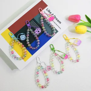 Flat lay of colorful acrylic beaded keychains with smiley flowers and cartoon charms
