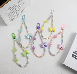 Detailed macro view of colorful beaded phone straps with polka dot bow pendants