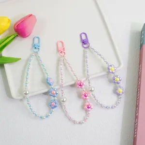 Detail of handmade flower charms with pearls for phone cases and keychains in a tray
