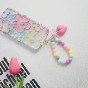 Blumen-Handyhülle mit Wellenrand und pastellfarbener Perlenkette mit Herzanhänger