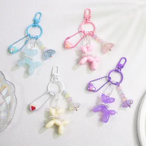 Close-up of four colorful balloon dog keychains in pink, blue, purple, and white resin