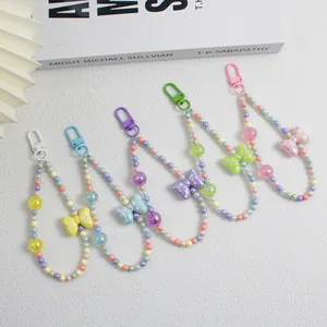 Detailed view of five colorful beaded phone straps with cute bow charms in pastel tones