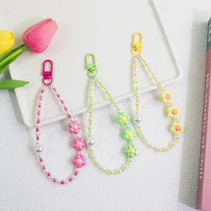 Detailed view of floral pearl beaded keychains in pink, green, and yellow floral designs