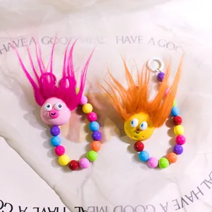 Close-up of cute Y2K fuzzy monster keychains with colorful beads and long fur textures