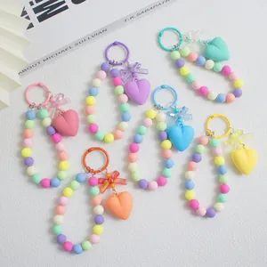 Flachbild von bunten Macaron-Perlen-Armband-Schlüsselanhängern mit Schleifen und Herzanhängern