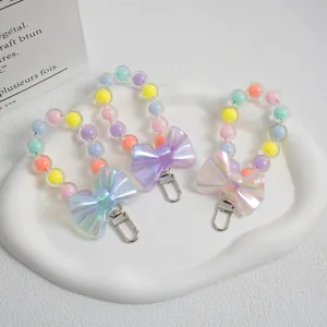 Detailed view of macaron bead phone charms with colorful bows and metallic lobster clasps