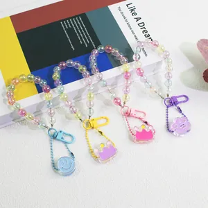 Macro detail of colorful iridescent acrylic beaded keychains with smiley face and crown charms
