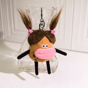 Cute fuzzy potato plush keychain with funny sausage lips and pink star clips on a bag