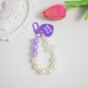 Dettaglio portachiavi a perle con tulipano viola e ciondolo a cuore per borsa o cellulare