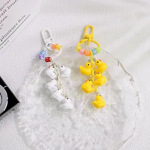 Detailed shot of cute duck charms with smiley beads on white and yellow keychains