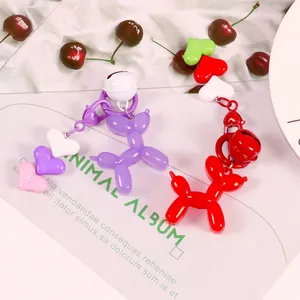 Charming jelly balloon dog keychains in purple and red with heart charms and bells