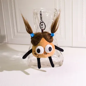 Macro detail of plush potato keychain with pigtails and sausage mouth hanging on glass