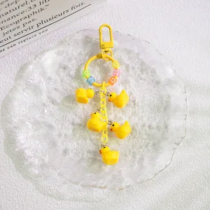 Detail of yellow duck keychain with five resin charms and colorful smiley beads