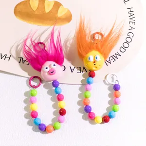 Detail of cute colorful fuzzy doll keychains with vibrant beads and unique funny expressions