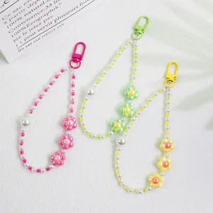 Detailed macro view of colorful beaded flower keychains with pearls and metal lobster clasps