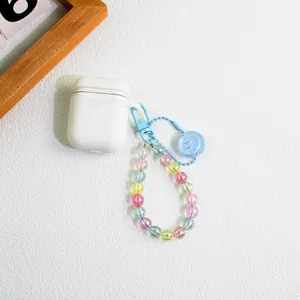 Macro shot of colorful beaded keychain with blue smiley charm on a white headphone case