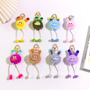 Detailed group shot of eight colorful plush monster keychains with funny expressions