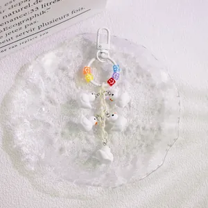Detail of white duck charms keychain with resin smile blocks and plastic chain link