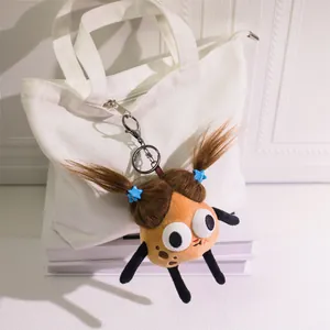 Funny fuzzy potato plush keychain with big eyes and star clips on a white tote bag