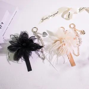 Elegant feather keychain with pearls and heart pendant for bags and phones in champagne and black