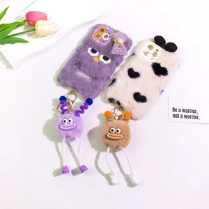 Close-up of fluffy purple phone case with cute monster charm and embroidery details