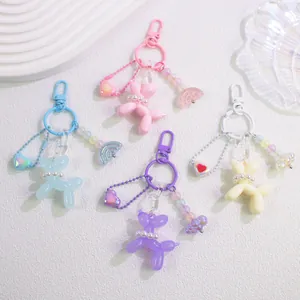 Detail of colorful resin balloon dog keychains with pearls and heart pendants on white base