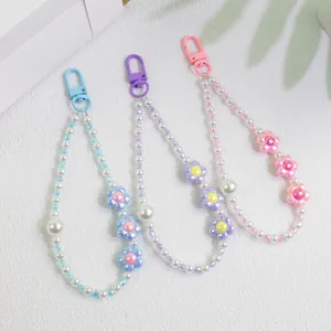 Detailed view of beaded flower keychains with pearls in blue, purple and pink colors