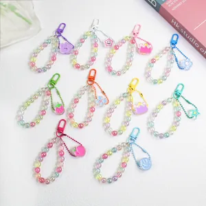 Flat lay of colorful acrylic beaded keychains with resin flower and smiley face charms