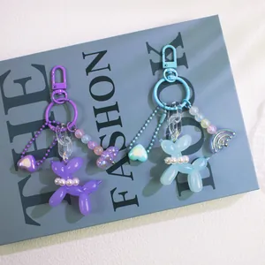 Cute resin balloon dog keychain in lavender and sky blue with pearl collar and charms