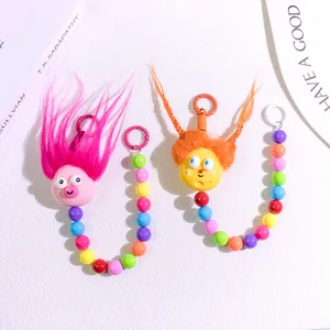 Detail of cute fluffy doll pendants with colorful beads and metal hooks for bags